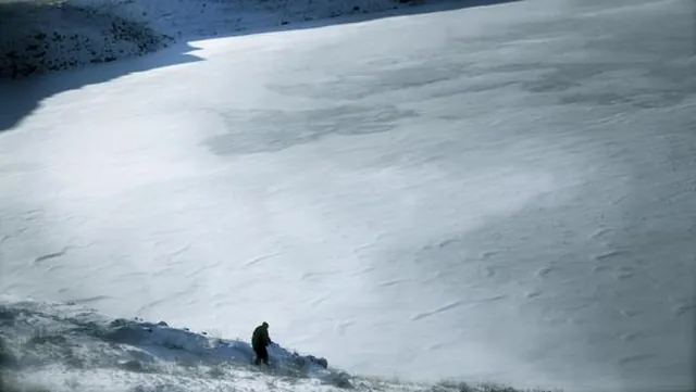 A lone figure beside a frozen lake in After the Apocalypse.