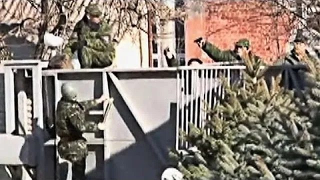 Uniformed men at a metal gate in the Guardian film about Crimea.