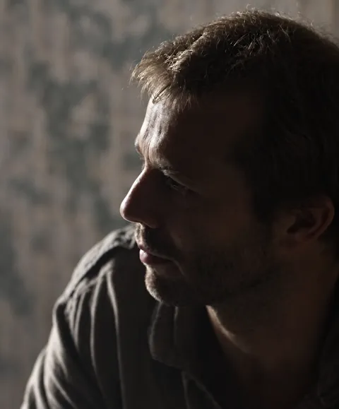 Earlier portrait of Antony Butts in profile, lit by a window